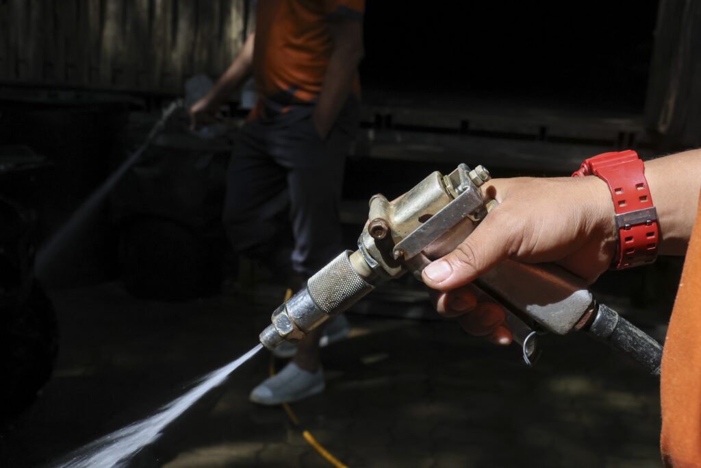 Worker,Hand,Holding,High,Pressure,Spray,Gun,With,Water,To